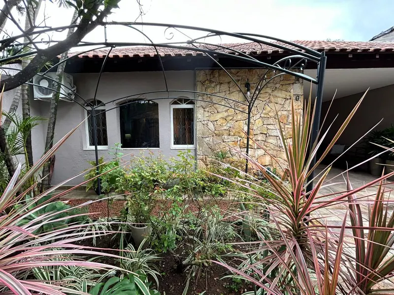 Frente do consultório: casa com parede de pedra, janelas em arco e jardim
